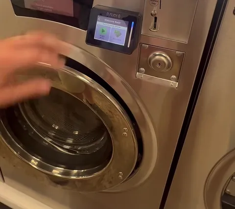 A washer's card reader and coin slot - tap your card or scan with the app to start the machine